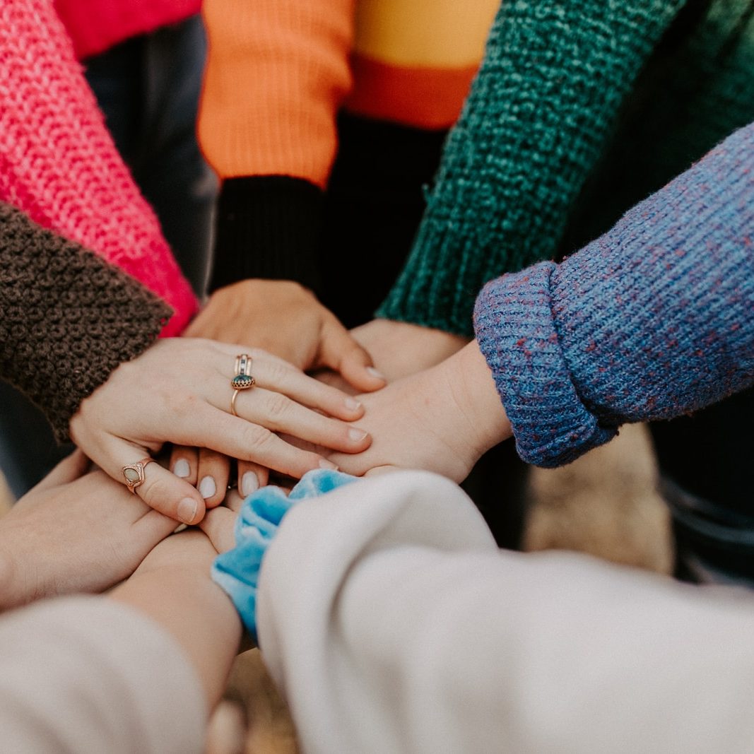 Photo by Hannah Busing person in red sweater holding babys hand
